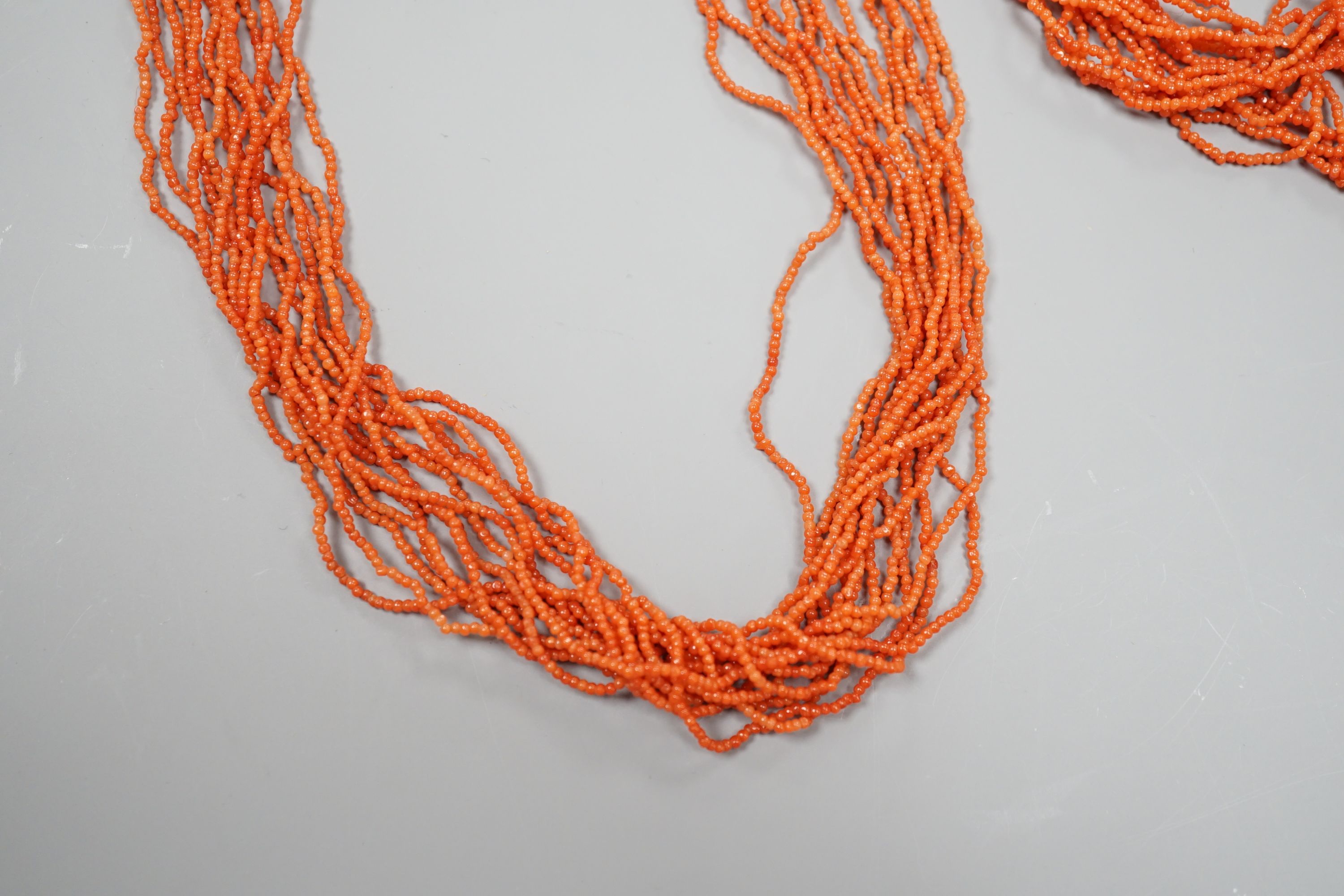 A multi strand coral bead necklace, 39cm and matching bracelet, 15.5cm, both with yellow metal barrel shaped clasps.